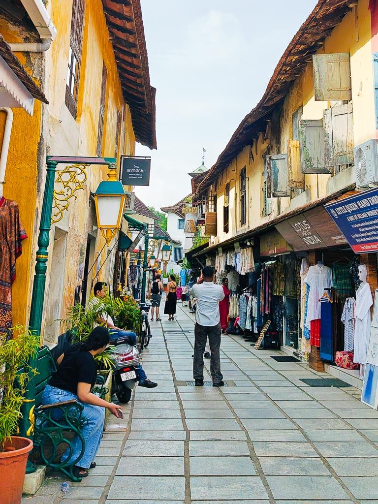A colonial-era street in Fort Kochi with shops and passersby