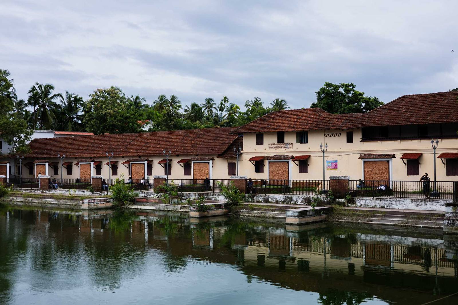 A traditional Kerala heritage building beside a temple pond near Kozhikode